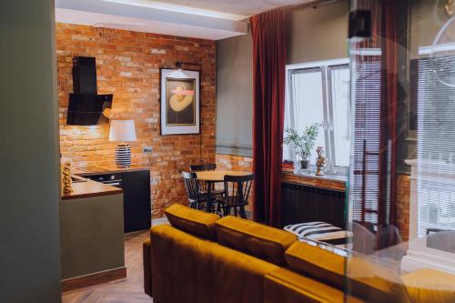 克维曾Apartamenty Zamkowe Centrum的一间带黄色沙发的客厅和一间厨房