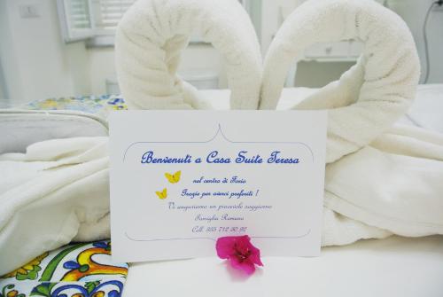 伊斯基亚Apartment Casa Suite Teresa , centro di Forio , Ischia的床上的标志,带毛巾动物