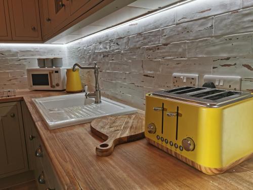 伯翰姆昂斯Seashell luxury apartment的厨房的柜台上设有黄色烤面包机
