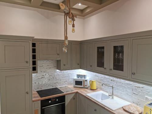 伯翰姆昂斯Seashell luxury apartment的厨房配有白色橱柜、水槽和微波炉