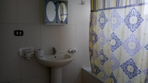 巴亚希贝Private Apartments in Caribe Dominicus solo adultos的一间带水槽和淋浴帘的浴室