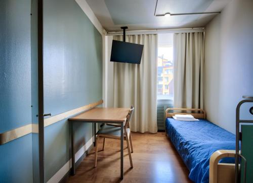 赫尔辛基欧洲旅馆的一间卧室配有一张床、一张桌子和一张桌子