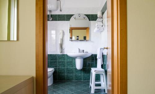 奎尔西亚内拉罗萨德尔提兰诺酒店的一间带水槽、卫生间和镜子的浴室