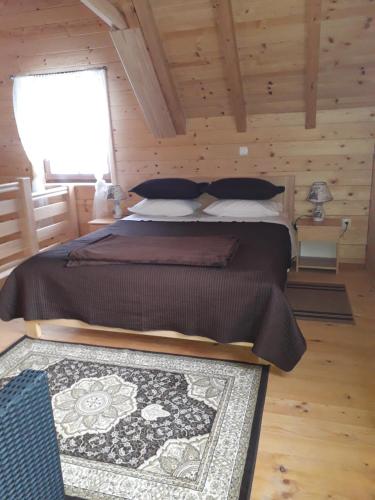 Donji Babin PotokPlaninske kuce Good Night的木制客房内的一间卧室配有一张大床