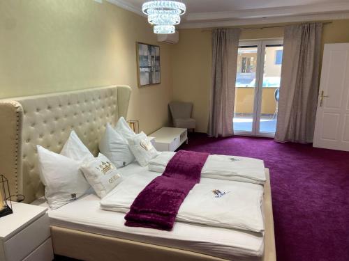 GabersdorfHotel Restaurant Hesch的一间卧室配有一张大床,铺有紫色地毯