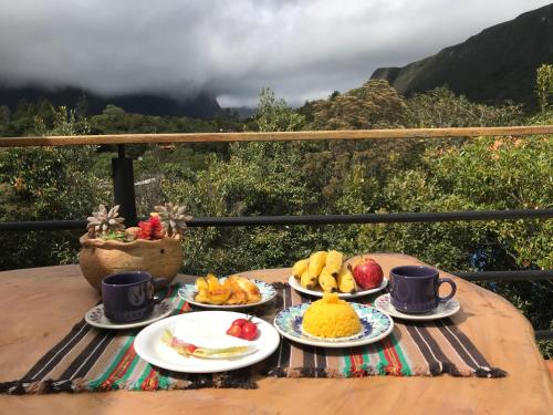 韦尔卡鲍Entre Montanhas Capão的一张桌子,上面放有水果盘和杯子