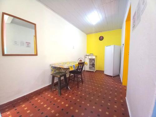 圣保罗Infinito House - Casa inteira的客房配有桌椅和冰箱。