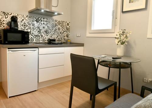 塞维利亚MS4 Apartamentos Nervión的小厨房配有小桌子和小桌子