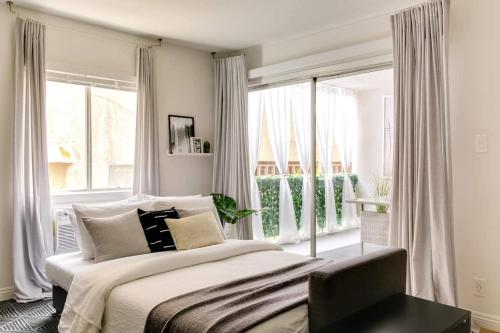 长滩Sophisticated Long Beach Suite with Patio Dining and Parking NRP21-00185的一间卧室设有一张床和一个大窗户