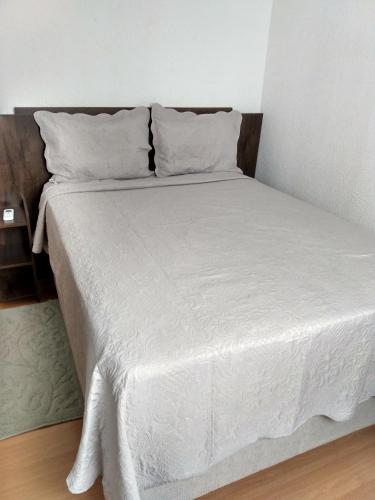费拉迪圣安娜Plaza Fraga Maia的一张带白色床单和枕头的床