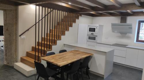 拉赫A Casa de Costa的厨房设有木桌和楼梯。