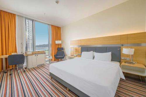 巴统巴统丽笙酒店的酒店客房设有一张大床和一张书桌。