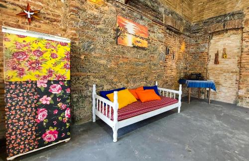 普拉杜Hostel Casa Grande的客房设有一张带色彩缤纷枕头的床。