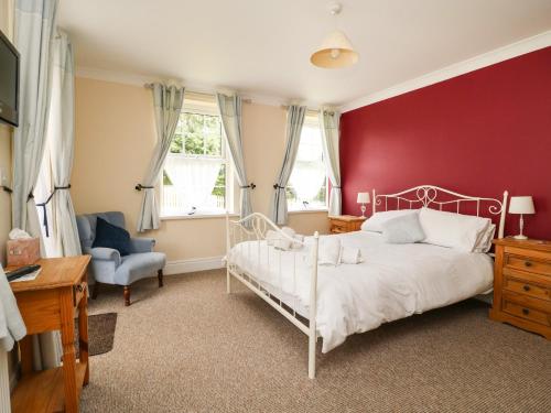 BentleyWoodhill的卧室配有白色的床和红色的墙壁