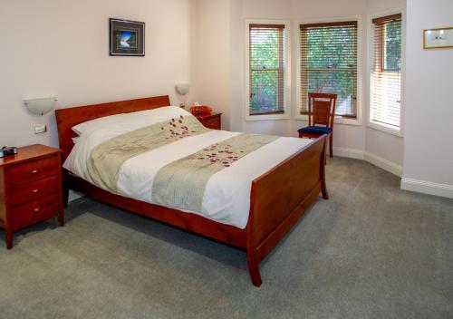 塔南达Lochnagar Barossa的卧室配有1张床、1张桌子和1把椅子
