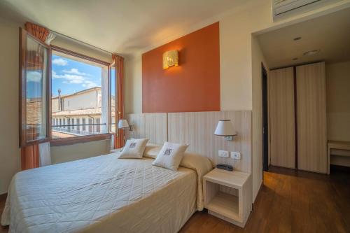 佛罗伦萨德拉斯吉诺日艾酒店的一间卧室设有一张大床和一个大窗户