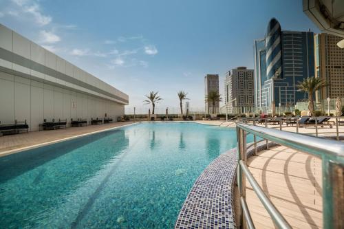 富查伊拉诺富特富查伊拉酒店的一座建筑物中央的游泳池