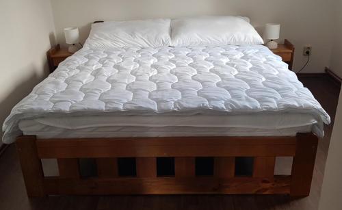 科热诺夫Apartmán Jizerka的一张带白色床单和枕头的床