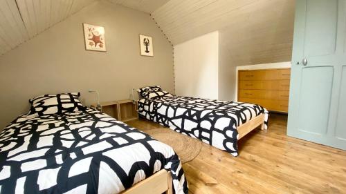 勒克罗图瓦Le 5 en baie, maison pour 4 personnes的一间卧室配有两张黑白床单