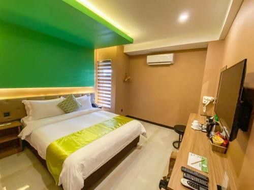 麦克坦Vivien's Hotel的一间卧室设有一张大床和绿色的墙壁