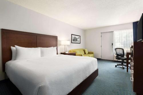 萨尼亚Days Inn by Wyndham Sarnia Harbourfront的酒店客房设有一张大床和一张书桌。