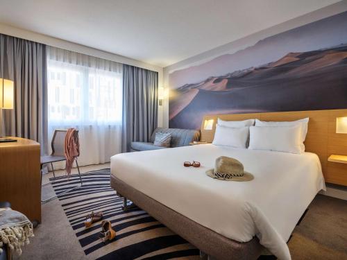 帕莱索诺沃特马西帕莱索酒店的酒店客房设有一张大床,上面有帽子