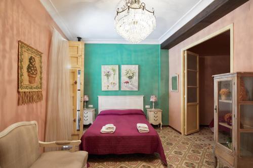 OnilRacó D Onil的一间卧室配有紫色的床和吊灯。
