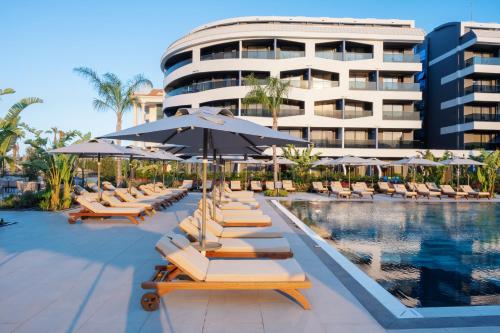 锡德Liu Resorts的度假酒店的游泳池配有躺椅和遮阳伞