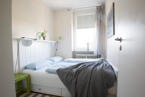威克奥夫弗尔Oland Whg 14 Nordseetraum的一间小卧室,配有一张带窗户的床
