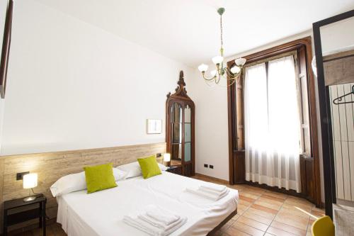 诺瓦拉Hotel Tornielli 9的卧室配有白色的床和窗户。