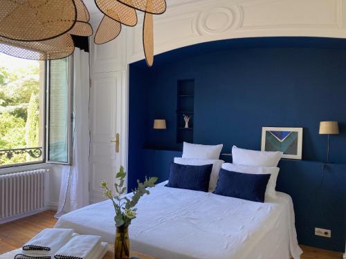 尼奥尔Chambres d'hôtes - La Maison 19的蓝色卧室设有一张带蓝色墙壁的大床