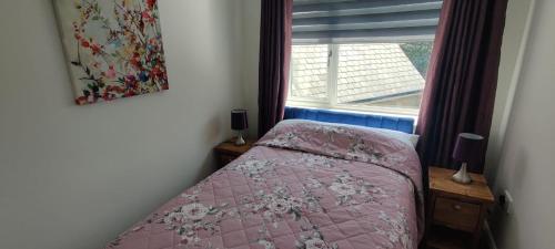 哈德斯菲尔德Golden Plover at Plover Cottage Lindley的一间小卧室,配有粉红色的床和窗户