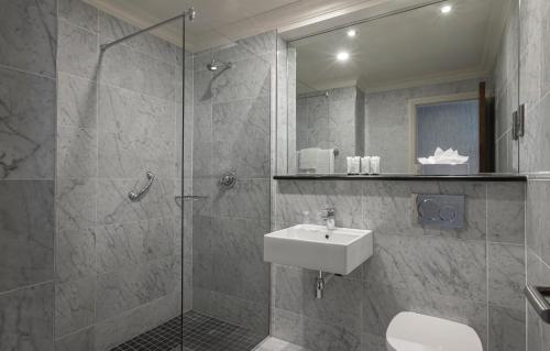 戈尔韦埃尔广场酒店的浴室配有盥洗盆和带镜子的淋浴