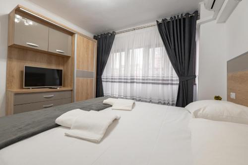 皮特什蒂Luxury Ultracentral的卧室配有一张白色大床和电视。