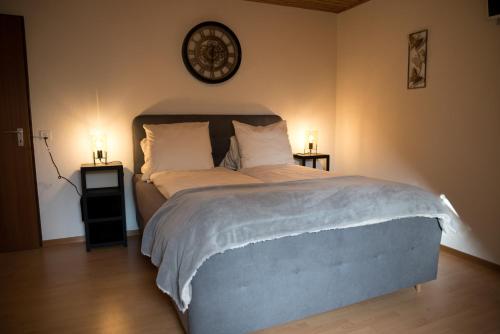 Les Bois传奇旅馆的一间卧室配有一张大床,配有两张桌子和闹钟