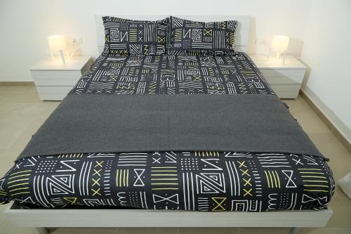 布林迪西Scirocco Guest House的一张配有黑白床单和枕头的床