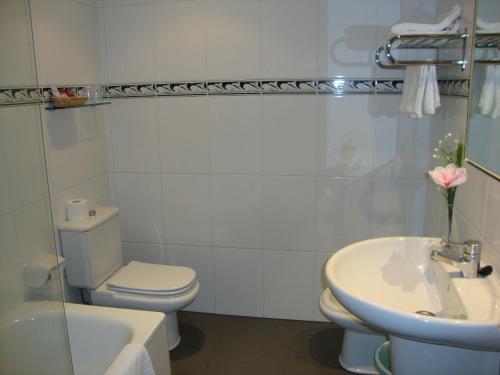 拉科鲁尼亚阿尔米兰特酒店的白色的浴室设有卫生间和水槽。