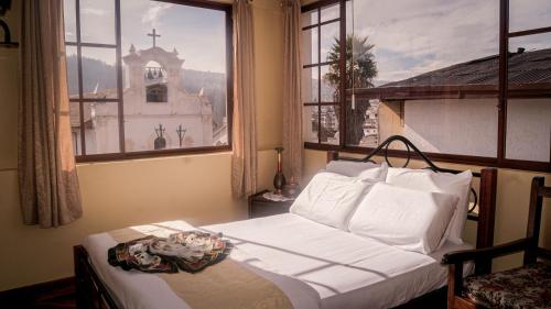 基多Hotel La Cierva de San Marcos的一间卧室设有一张床,窗户设有教堂