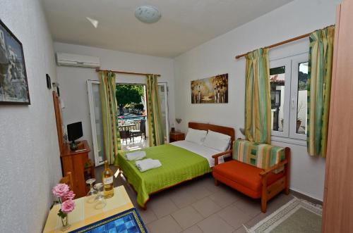 斯塔菲罗斯佩加萨斯公寓酒店的卧室配有床、椅子和窗户。