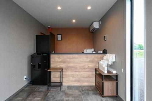 津山市HOTEL R9 The Yard Tsuyama的厨房配有柜台和冰箱。