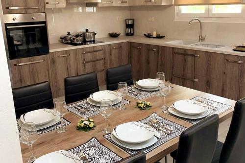 海若克利欧Helen`s Luxury Apartment的厨房配有带盘子和玻璃杯的桌子