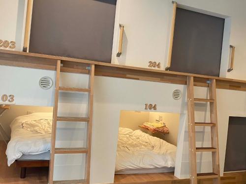 弘前市HOSTEL HIROSAKI -Mixed dormitory-Vacation STAY 32012v的客房设有两张双层床和一张床。