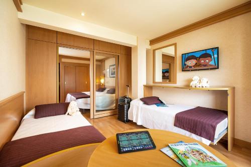 罗列特海岸Hotel Guitart Central Park Aqua Resort的酒店客房设有两张床和一张桌子。