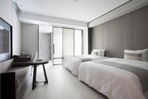 台中市缦和旅居的酒店客房设有两张床和一张桌子。