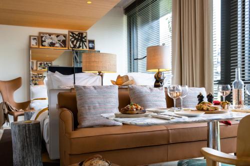 巴黎VILLA M的客厅配有沙发和带酒杯的桌子