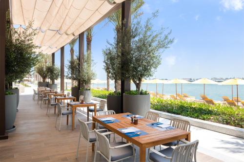 乌姆盖万乌姆盖万海滩葳达度假村 的一间设有桌椅的海洋餐厅