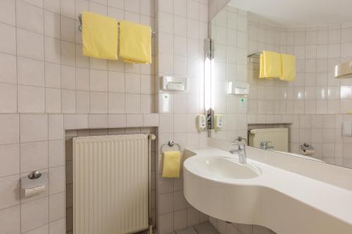 Freren萨勒海埃姆斯兰德酒店的白色的浴室设有水槽和镜子
