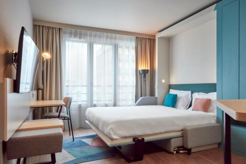 叙雷纳Aparthotel Adagio Paris Suresnes Longchamp的配有一张床和一张书桌的酒店客房