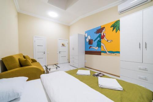 基辅Апартаменты WOW-hotel的一间卧室配有床、沙发和绘画