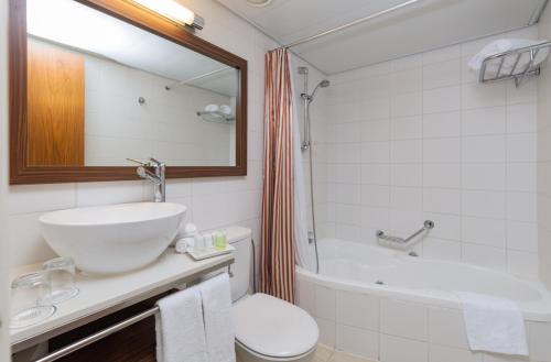 耶路撒冷普瑞玛罗亚尔绸酒店的浴室配有盥洗盆、卫生间和浴缸。